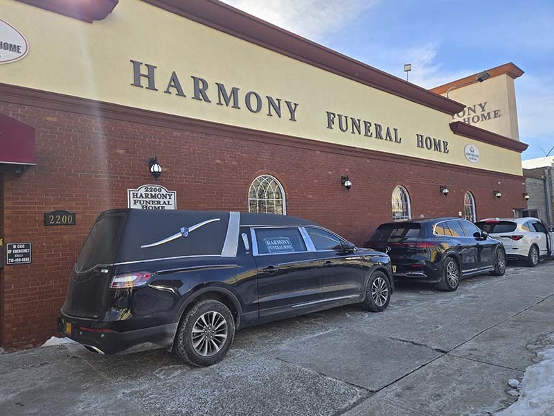 Exterior of Harmony Funeral Home in Brooklyn NY with funeral vehicles outside