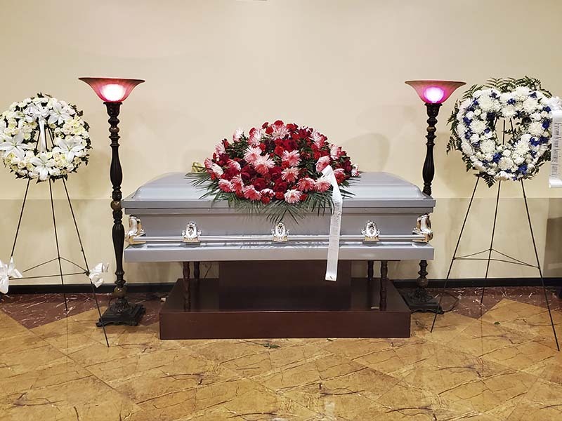 Traditional funeral service setup with casket and memorial flower arrangements