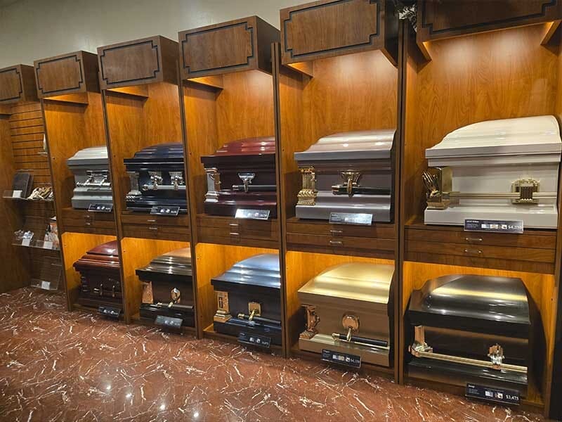 Various types of funeral caskets and burial containers displayed in a Brooklyn funeral home