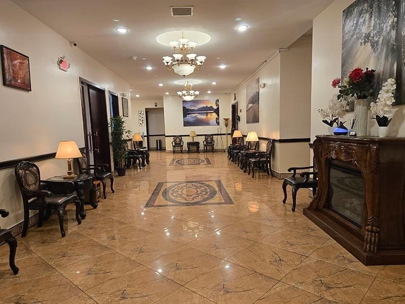 Interior hallway at Harmony Funeral Home in Brooklyn featuring elegant chandeliers, comfortable seating, and a welcoming atmosphere.