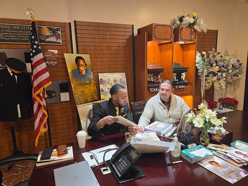 Funeral director assisting a family member with memorial service planning at Harmony Funeral Home in Brooklyn.