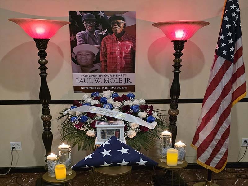 Veteran memorial tribute with American flag and floral arrangement honoring a loved one at Harmony Funeral Home in Brooklyn NY